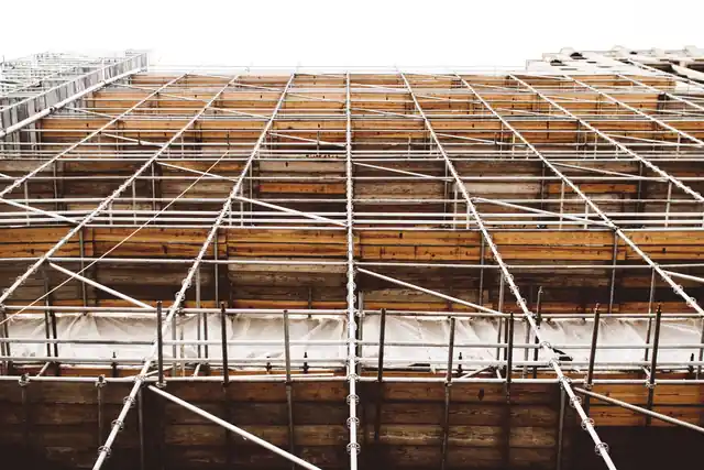 Grid of scaffolding tubes and timber boards supporting a slab for scaffolding rental in the UAE